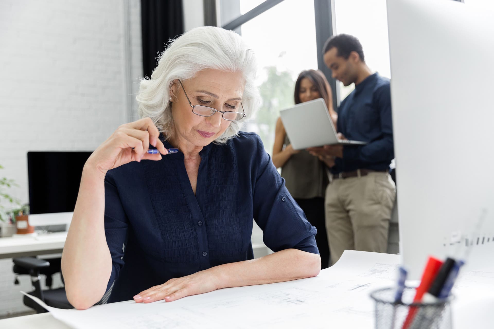Mature businesswoman working with documents while sitting at her workplace